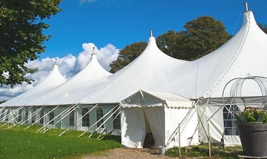 a line of portable restrooms in a shaded area, offering a comfortable experience for users in Casnovia